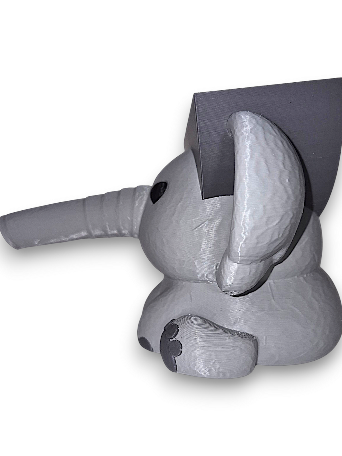 Gray 3D printed elephant sponge holder with a hollow trunk and flat top on a white background, side shot
