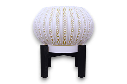 White sculptural planter with gold-accented lattice texture on black stand