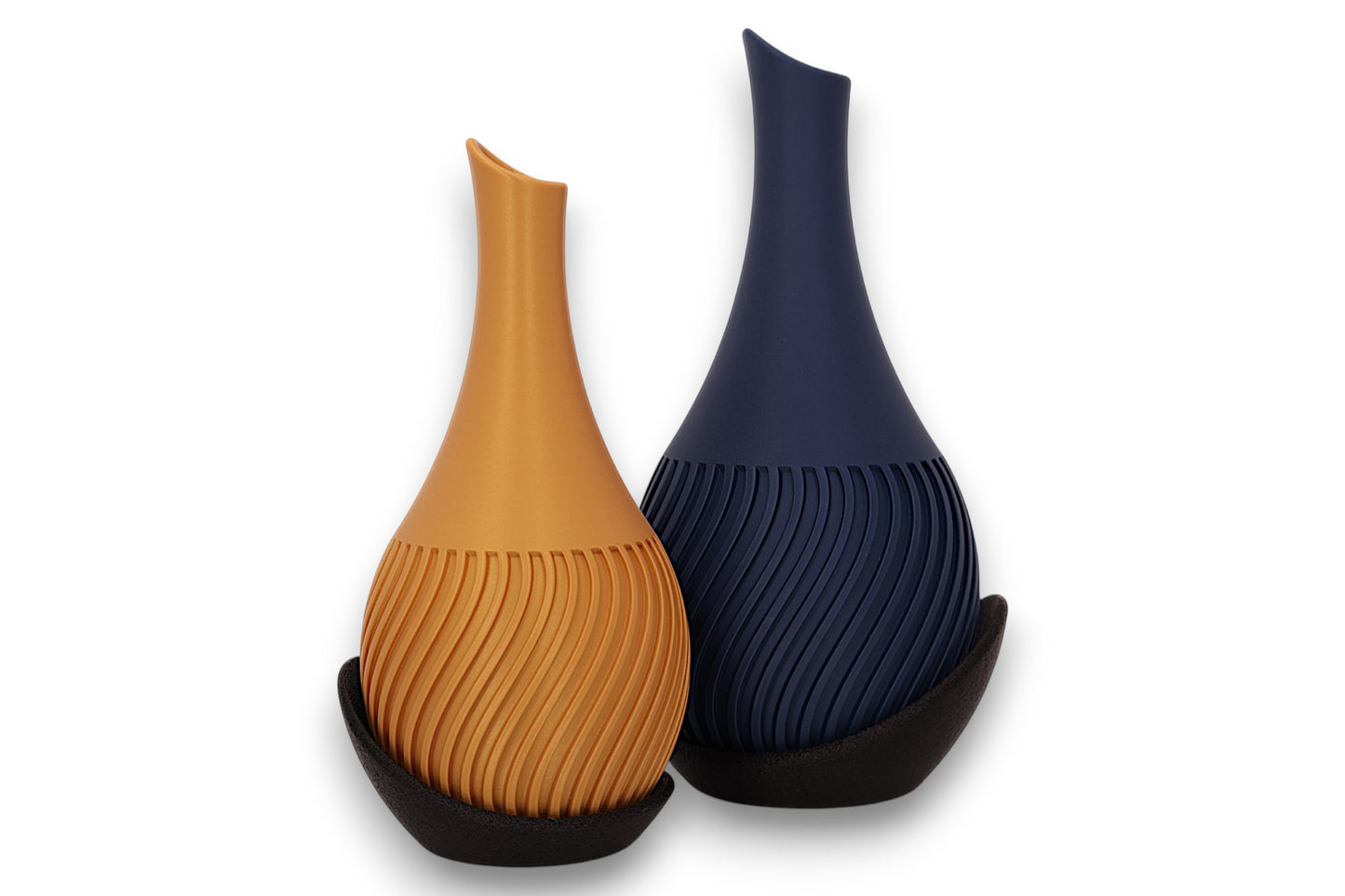 Gold and dark blue PLA vases – 3D printed with spiral ribbed texture and asymmetrical openings, each cradled in black curved base

