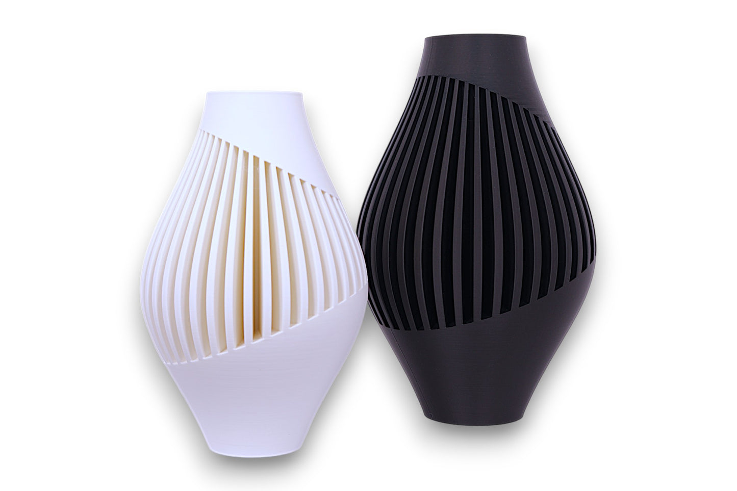 White and black PLA vases – 3D printed with tapered forms and spiral vertical slits, displayed side by side
