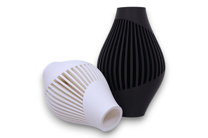 White and black PLA vases – 3D printed with spiral vertical slits and tapered silhouettes, shown upright and sideways
