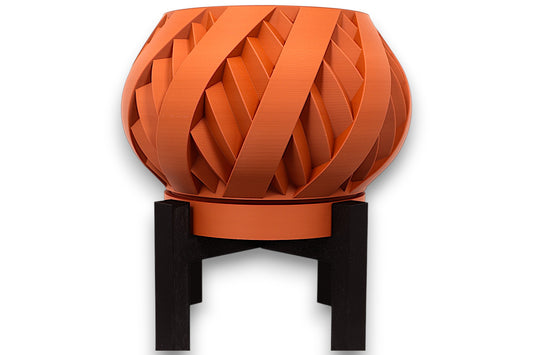Terracotta PLA planter – 3D printed with interwoven ribbon texture and bulbous form, elevated on black four-legged stand
