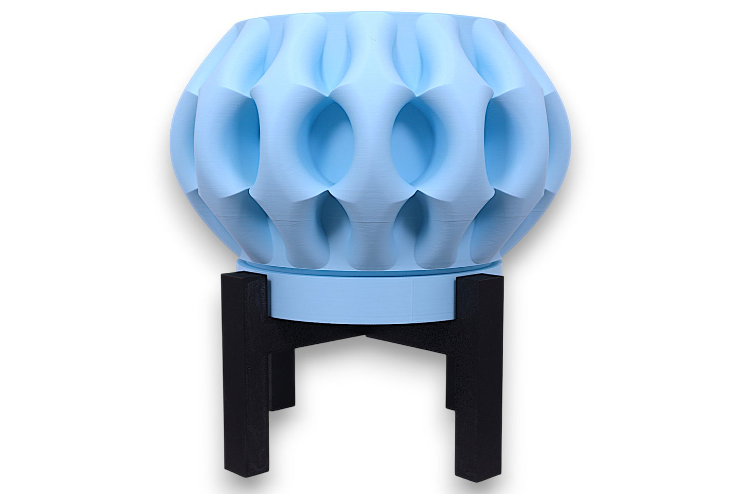 Light blue PLA planter – 3D printed with bulbous body and deep concave indentations, elevated on black four-legged stand
