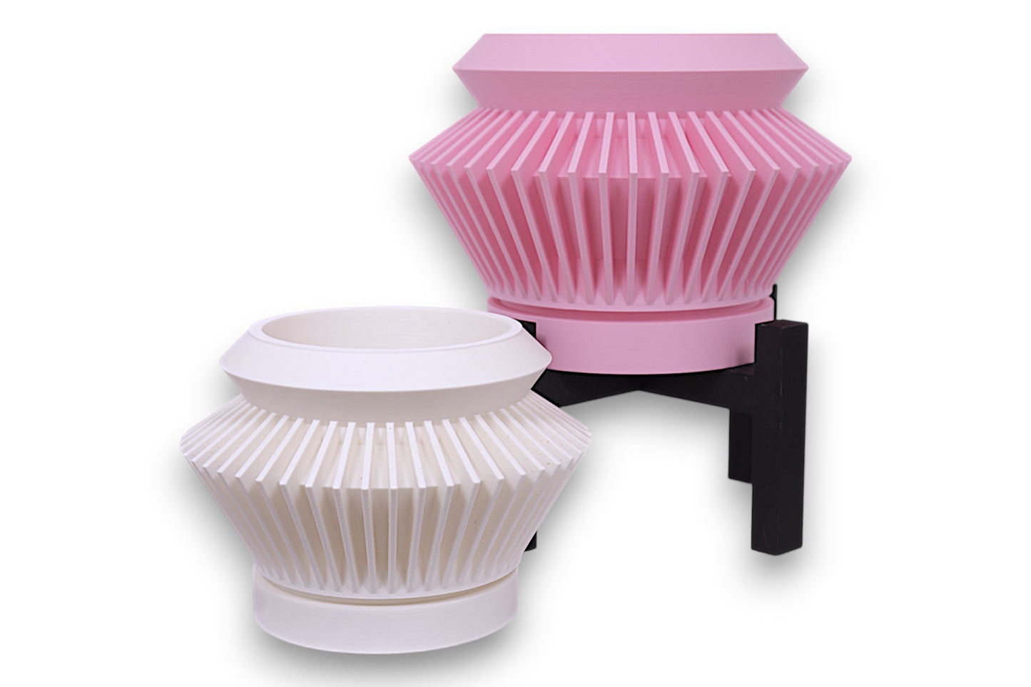 Pink and white PLA planters – 3D printed with tapered forms and vertical pleated textures, displayed at staggered heights
