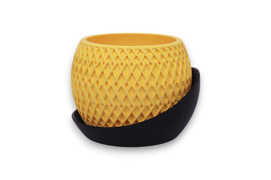 Yellow PLA planter – 3D printed with diamond-patterned surface, cradled in curved black base
