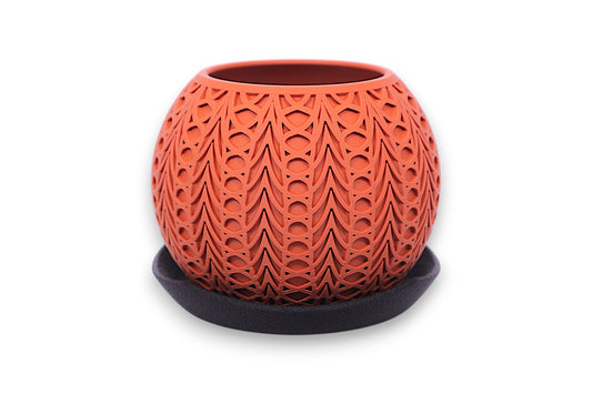 Terracotta PLA planter – 3D printed with symmetrical teardrop and oval cutouts, displayed on dark saucer
