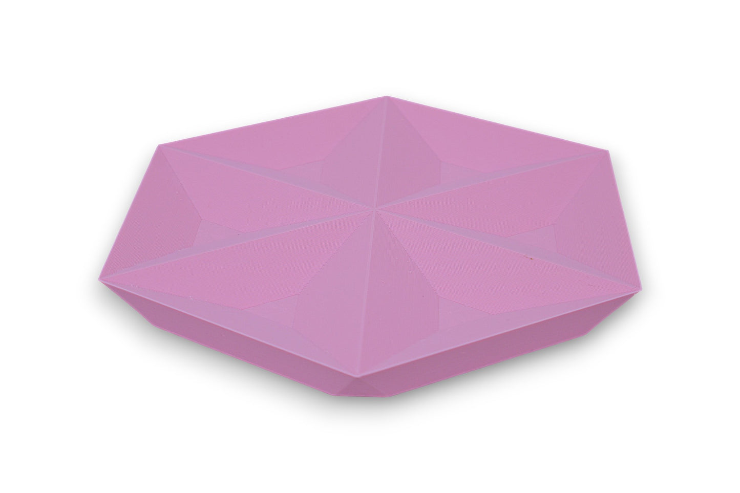 Pink hexagonal catch-all tray with raised triangular facets on top surface