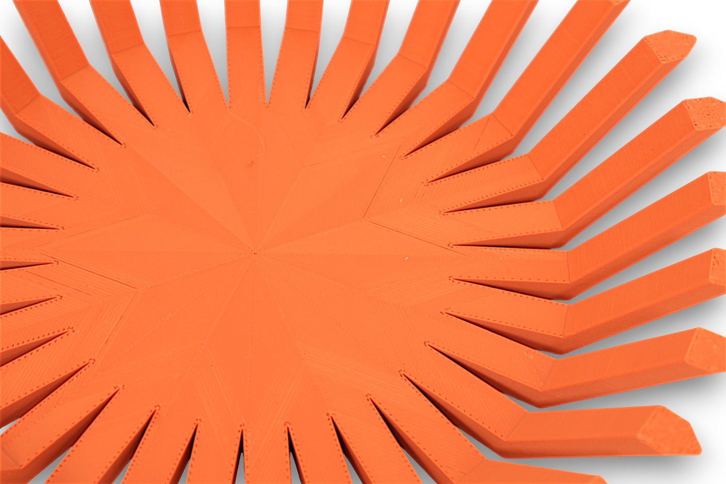 Terra cotta catch-all tray with angled rectangular prongs and faceted center base