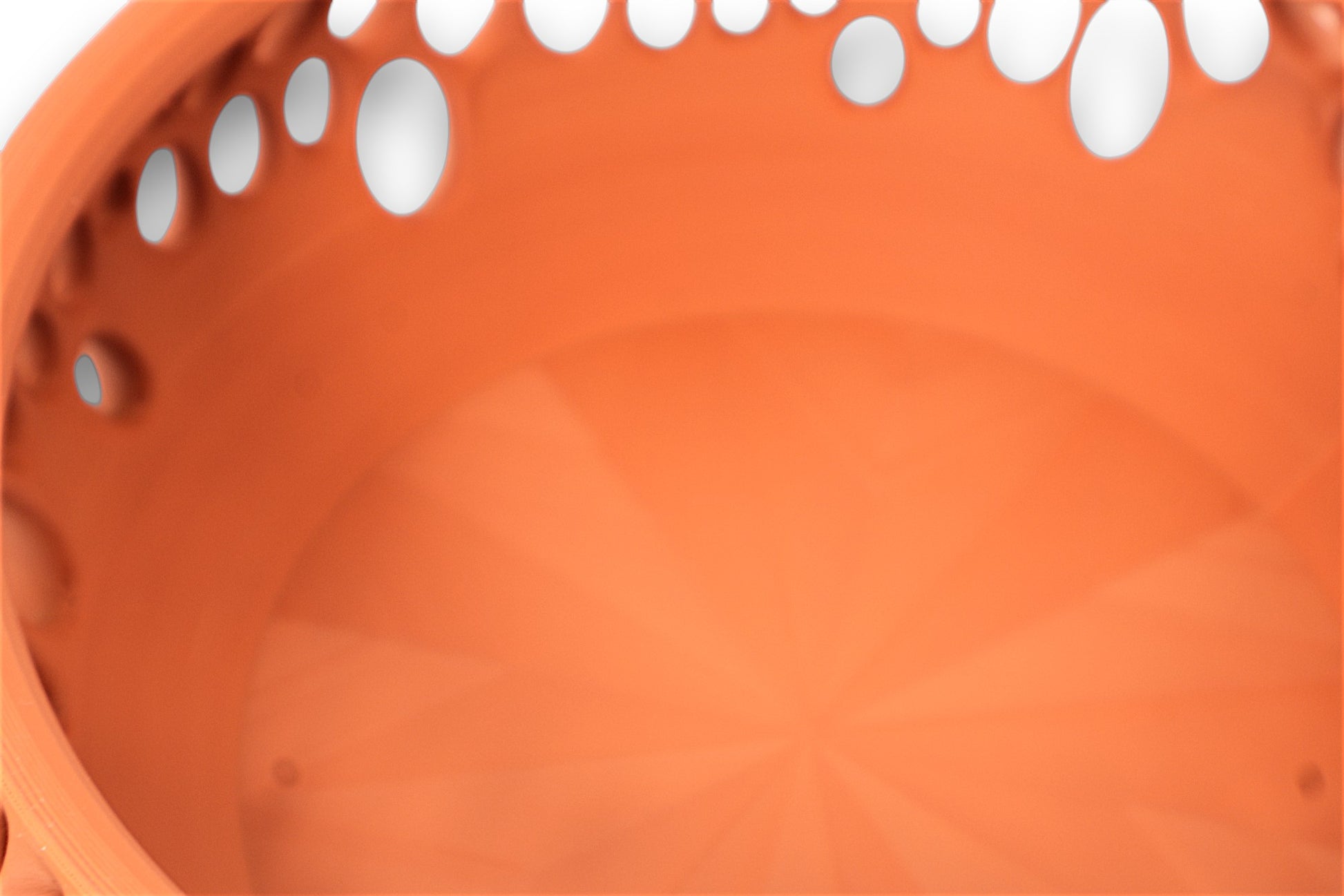 Terracotta catch-all tray with smooth interior and organic teardrop cutouts on rim