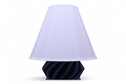 Lamp with a pleated white shade and ribbed black base on a white background