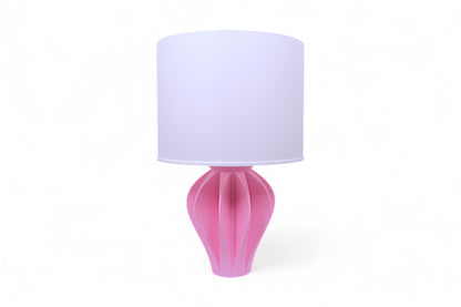 Table lamp – white pleated lampshade with sculptural pink petal-like base, shown against white background
