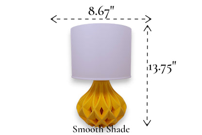 Table lamp – smooth white cylindrical lampshade with sculptural yellow interwoven base, 8.67" diameter × 13.75" height, labeled “Smooth Shade”
