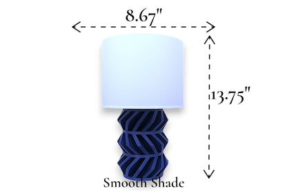Table lamp – smooth white cylindrical lampshade with geometric dark blue base, 8.67" diameter × 13.75" height, labeled “Smooth Shade”
