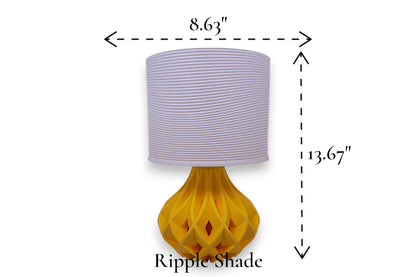Table lamp – white ripple-textured cylindrical lampshade with sculptural yellow geometric base, 8.63" diameter × 13.67" height, labeled “Ripple Shade”
