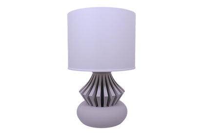 Table lamp with a white shade and decorative base on a white background