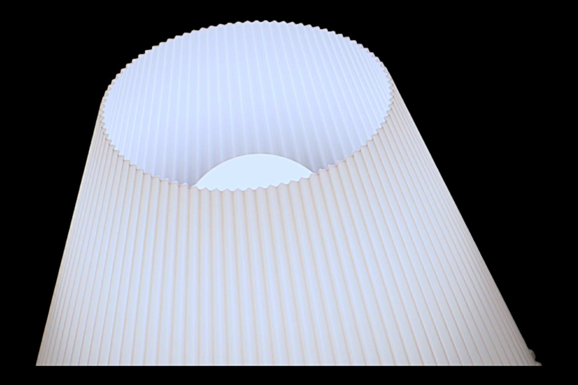 White pleated lampshade on a black background