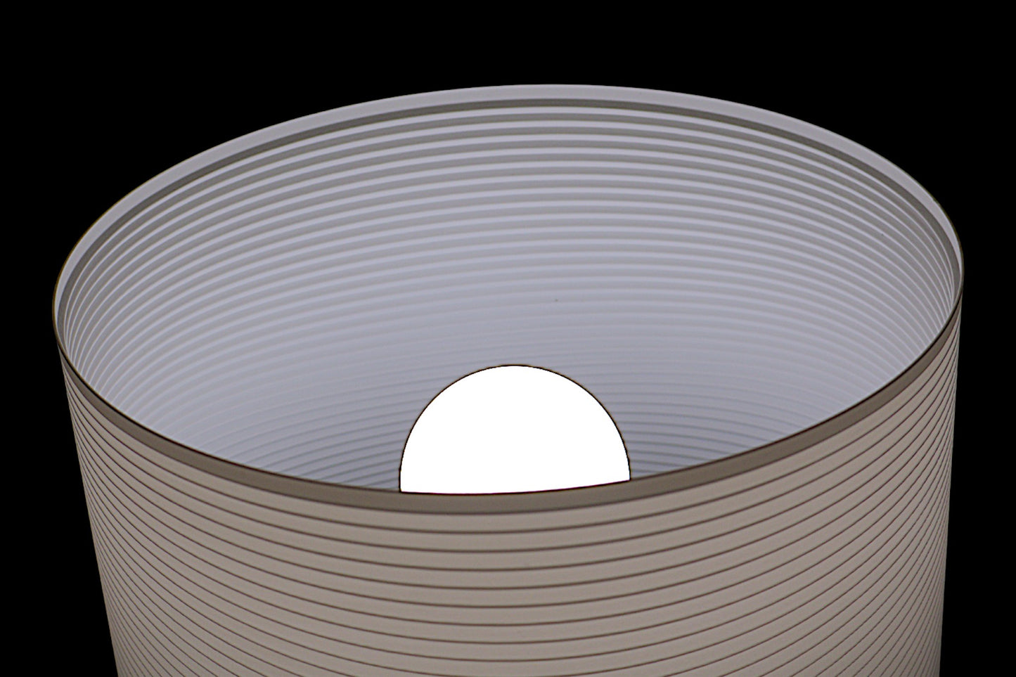 Cylindrical container with a white sphere inside on a black background