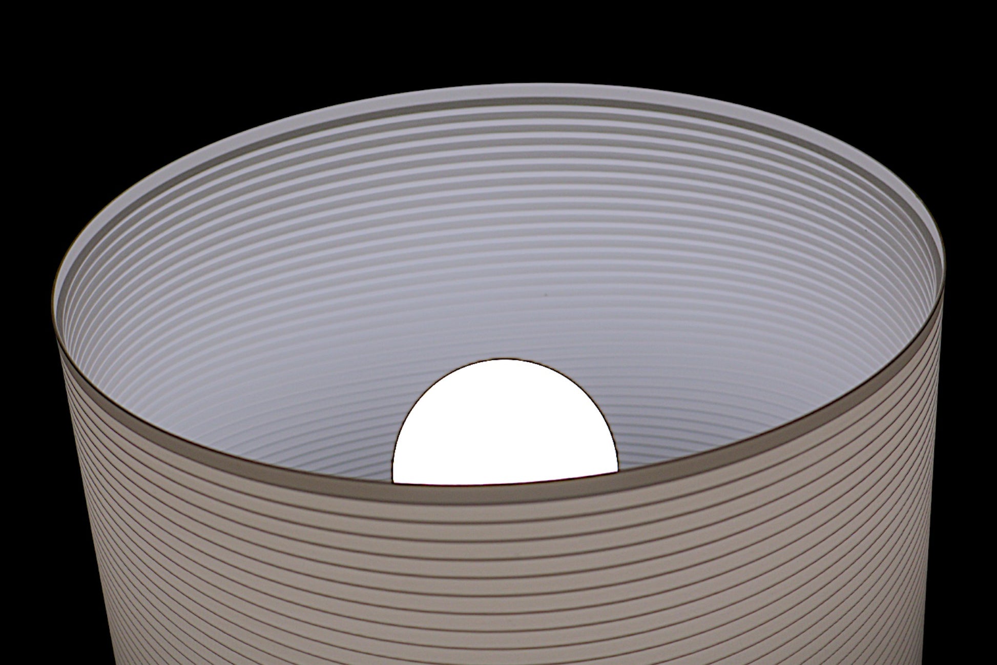 Cylindrical container with a white sphere inside on a black background