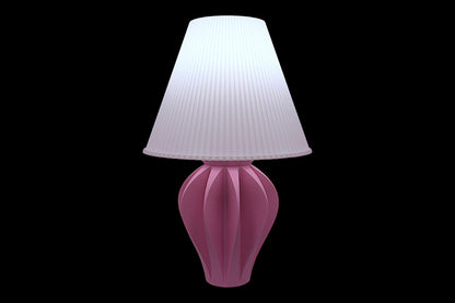 Pink table lamp with a white pleated shade on a black background