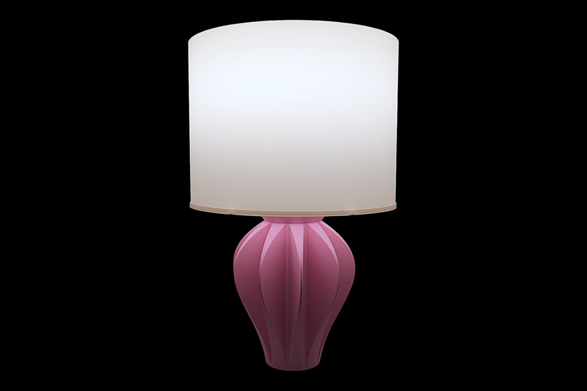 Pink table lamp with a white shade on a black background