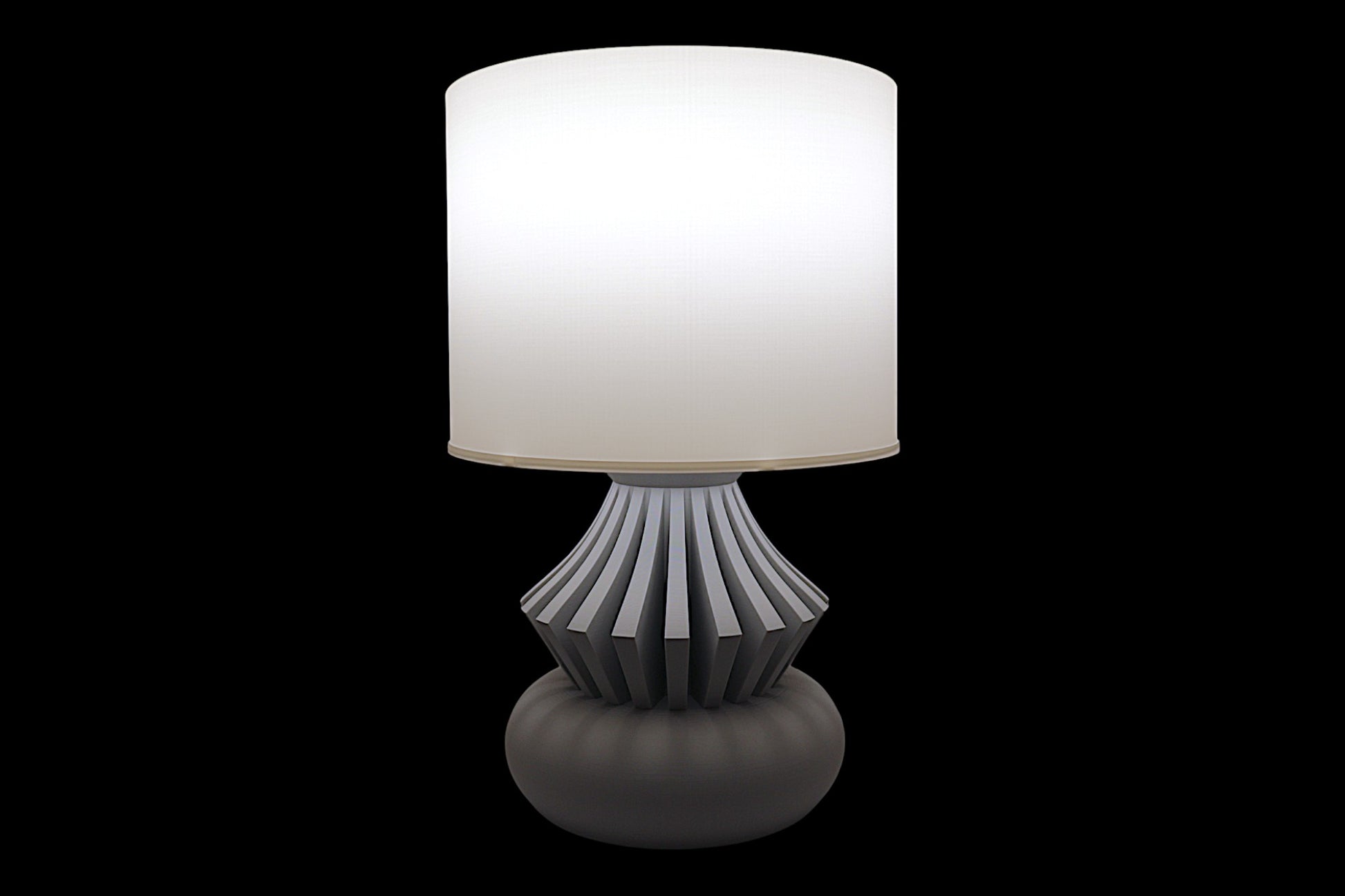 Table lamp with a white shade and decorative base on a black background