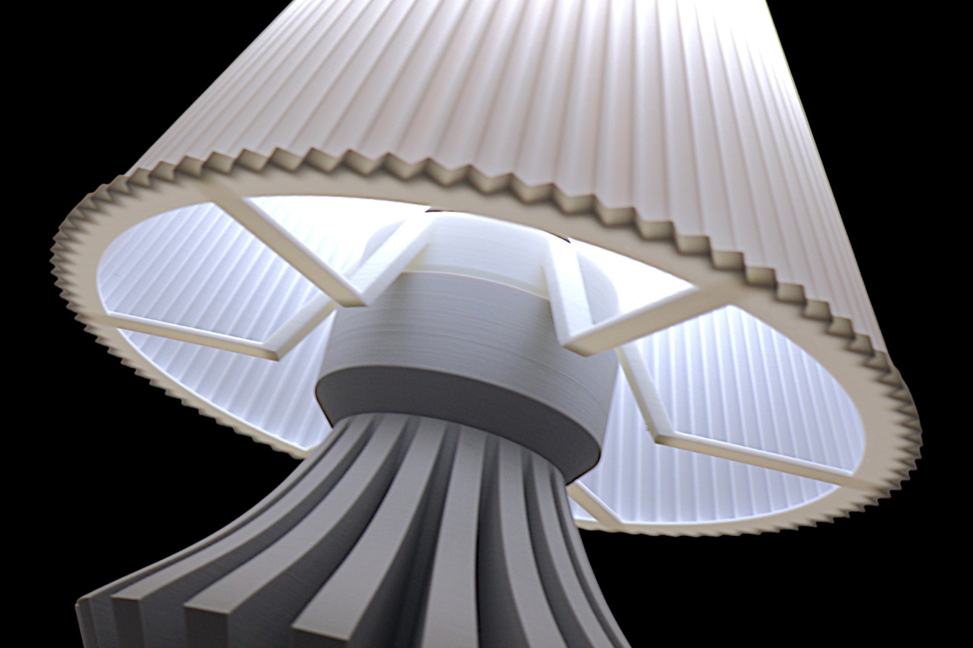 Close-up of a mushroom-shaped lamp with ribbed design on a black background