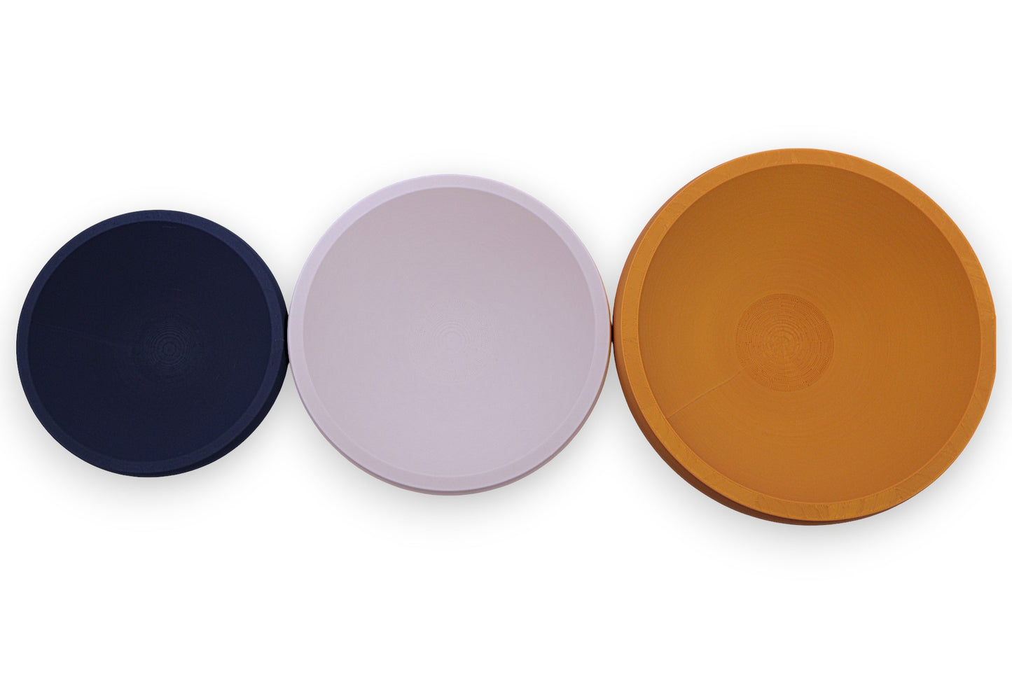 Catch-all trays – 3-pack set in navy blue, light pink, and orange PLA, round shape with smooth finish, shown empty
