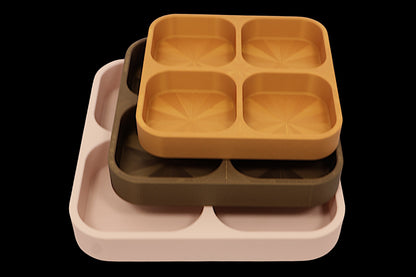 Set of three divided trays in different colors on a black background