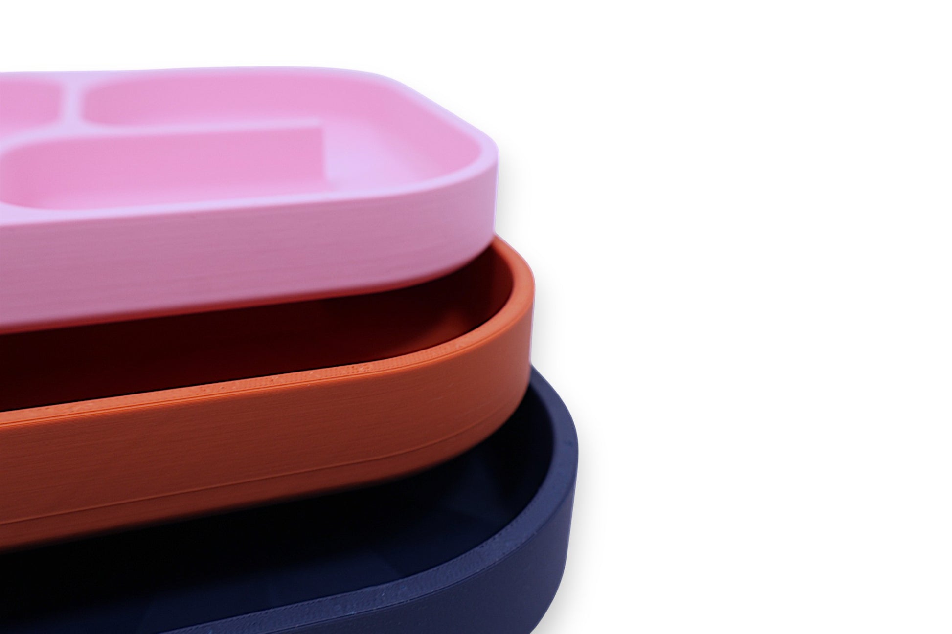 Stack of three colorful trays on a white background