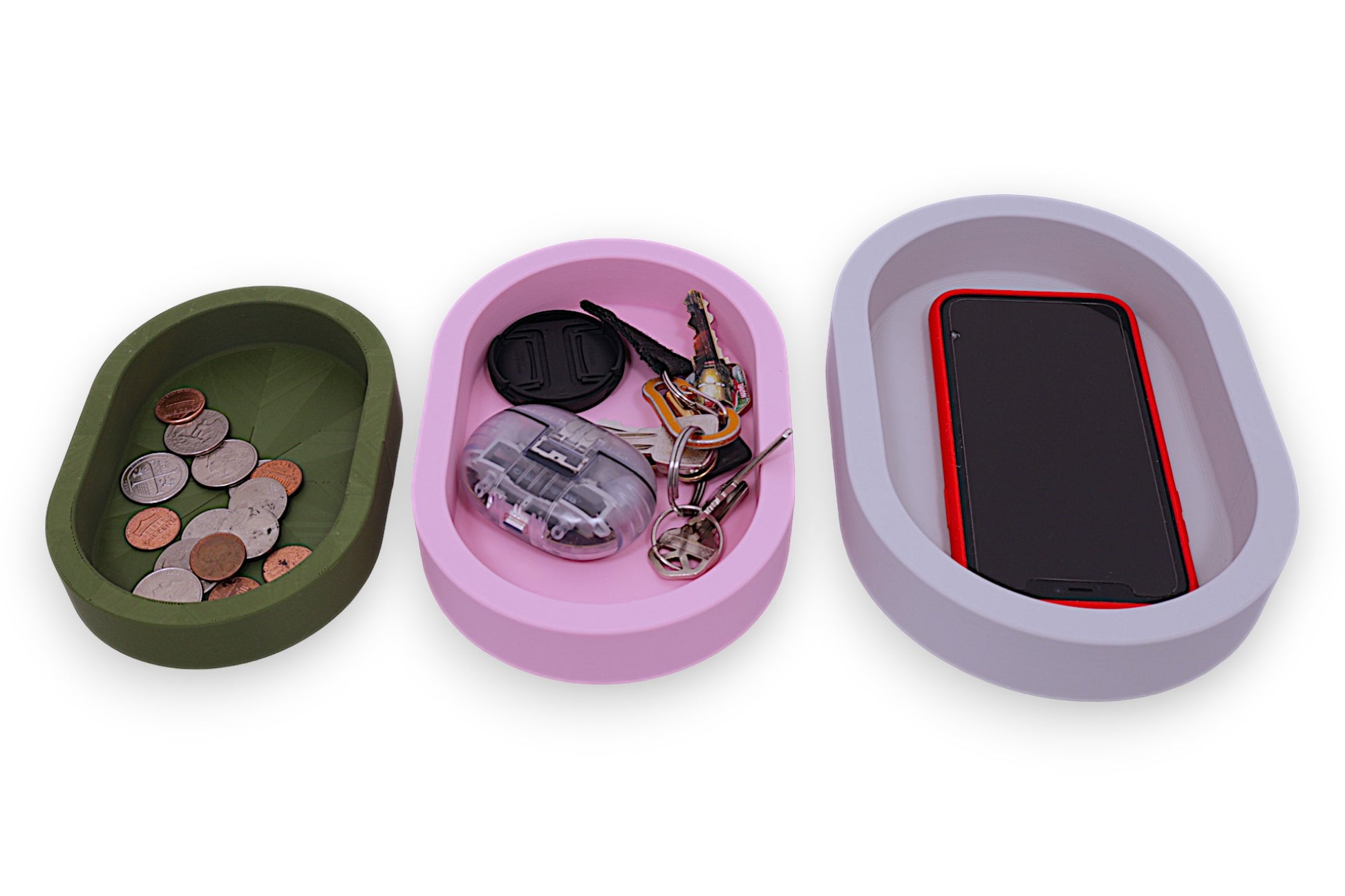 Catch-all trays – 3-pack set in green, pink, and white PLA, oval shape with smooth interiors, with items in them for size comparison 
