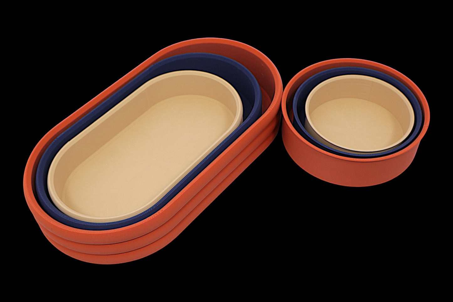 Catch-all trays – set in terracotta, navy blue, and Tan PLA, 3 round and 3 oval trays nested with geometric base patterns
