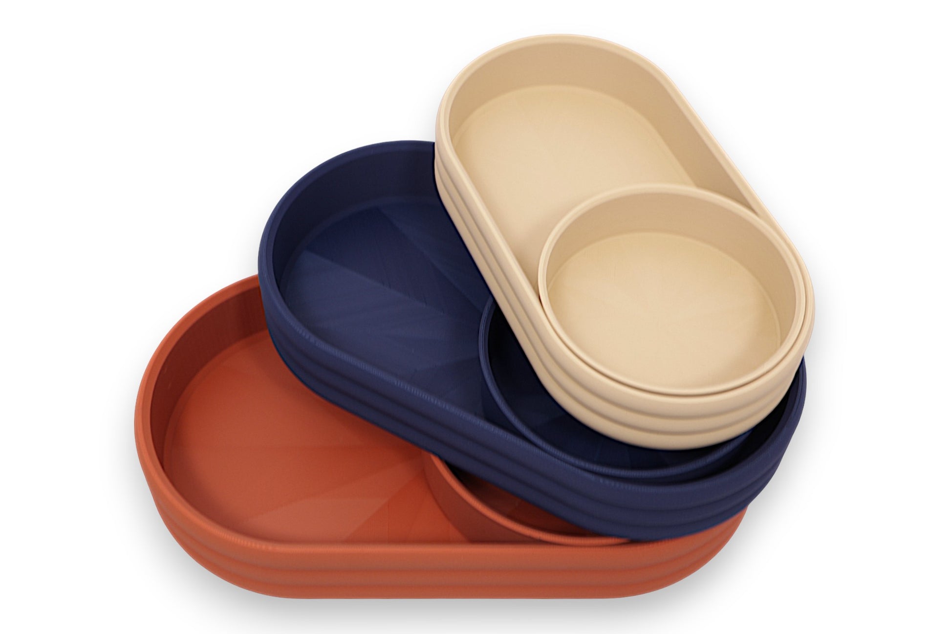 Catch-all trays – set in tan, navy blue, and terracotta PLA, nested oval shape with radial base pattern
