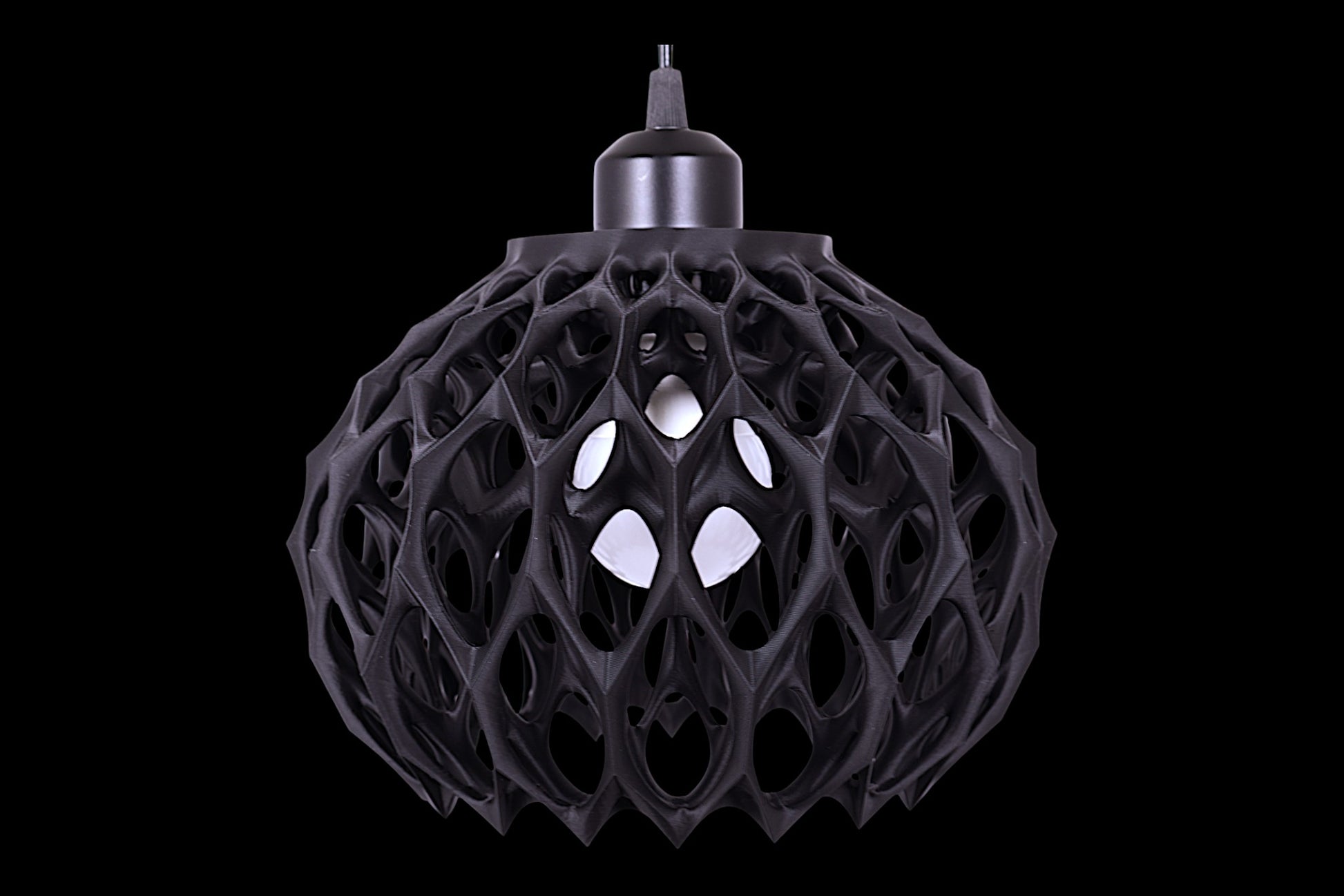 Black spherical pendant light with cellular lattice shell and visible bulb