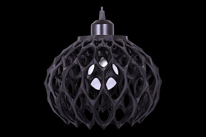 Black spherical pendant light with cellular lattice shell and visible bulb
