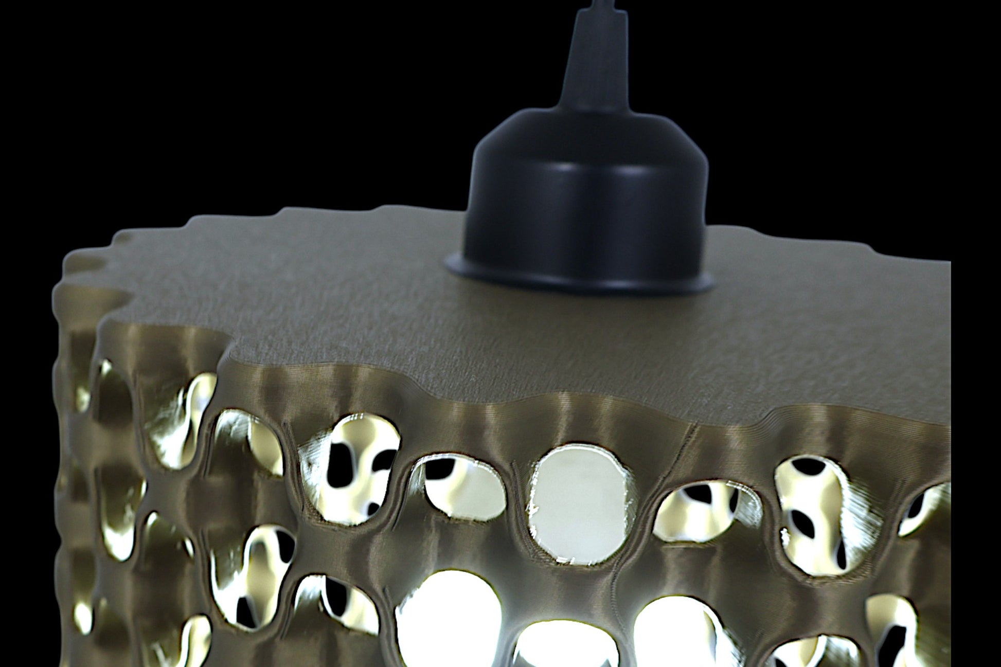 Pendant lamp detail – 3D printed honeycomb panel with hexagonal perforations, illuminated from behind
