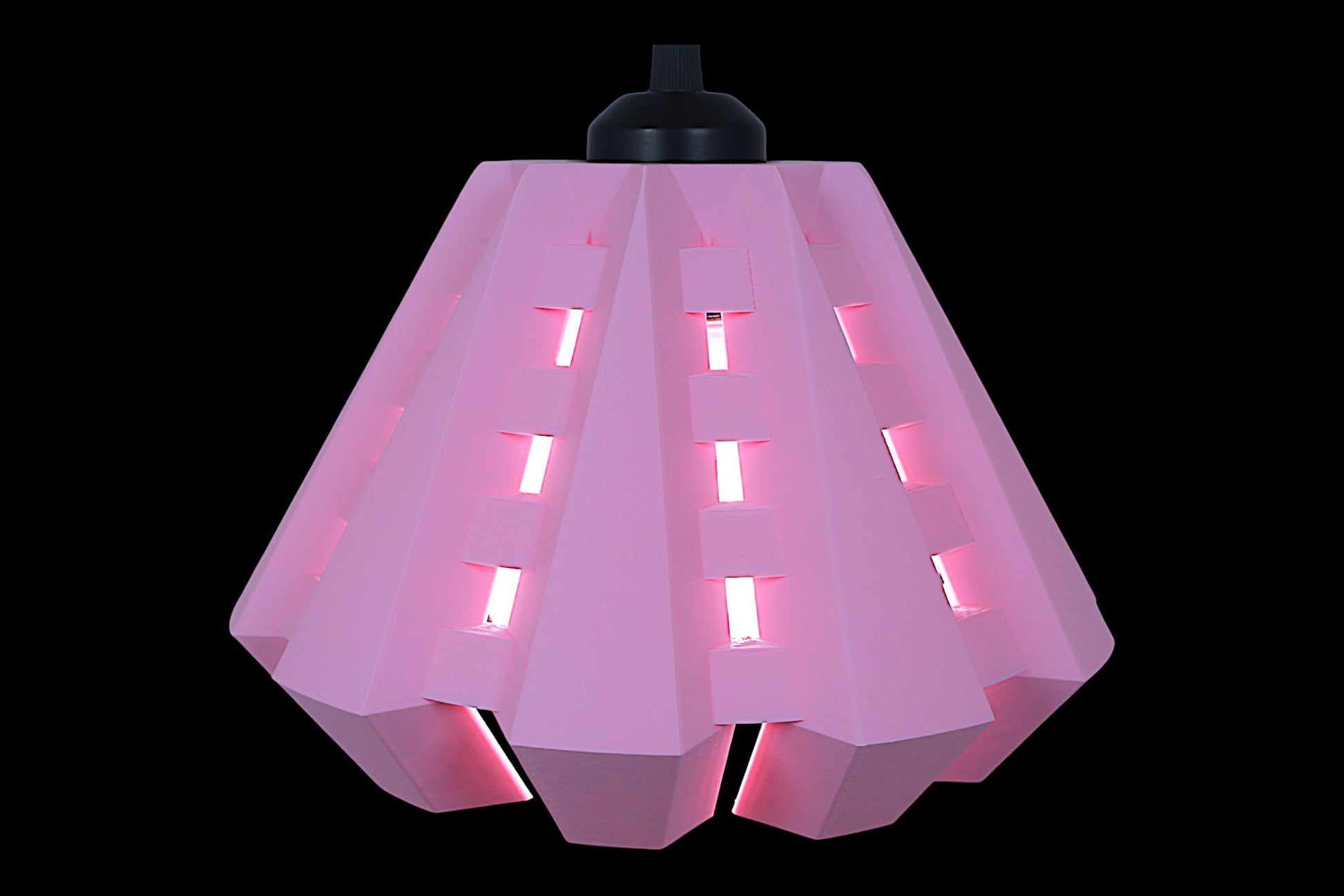 Pendant lamp – 3D printed in pink PLA with angular shell and rectangular cutouts, glowing bulb visible inside
