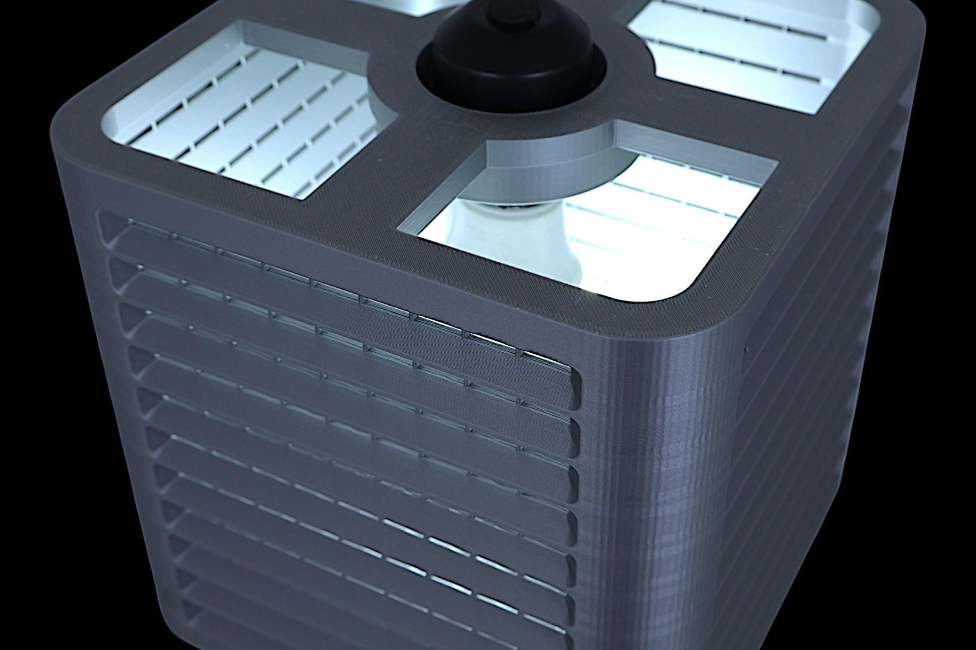 Coro pendant lamp – 3D printed with rectangular silver housing, front slats and grid-textured top, suspended by black cable