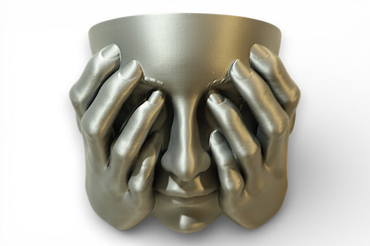 Metallic 3D‑printed face planter with multiple hands pressed against the face and cylindrical top opening