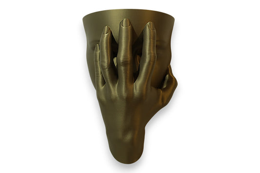 Bronze-toned 3D-printed sculpture of a human face partially obscured by a grasping hand, evoking themes of identity and emotional tension.