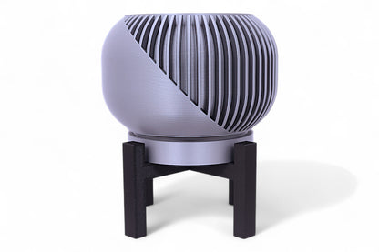 Silver planter with diagonal slatted upper half and smooth lower section on black stand