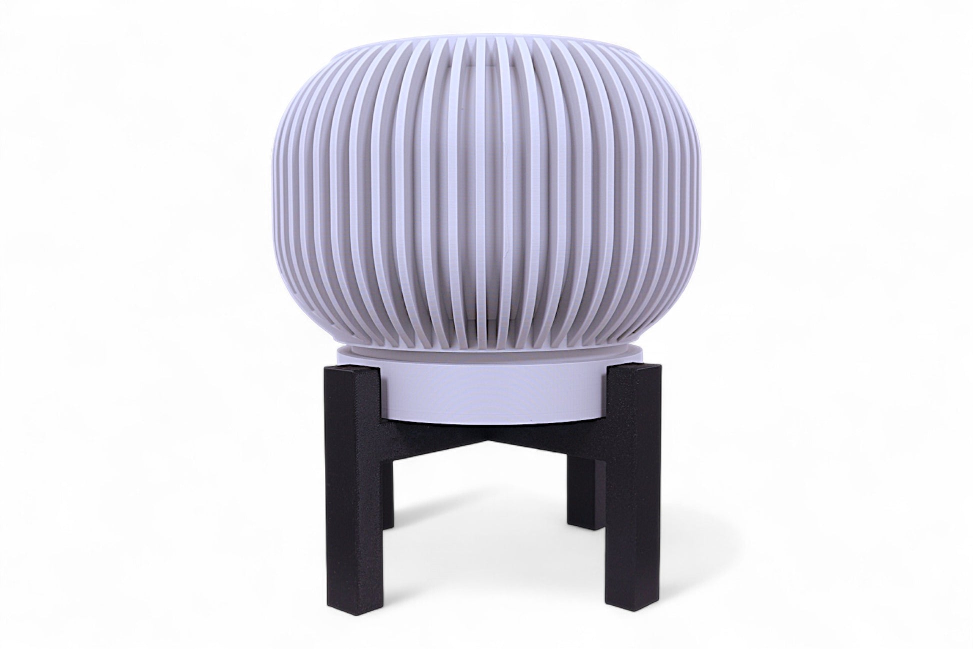 Gray planter with smooth rounded body on black four-legged stand