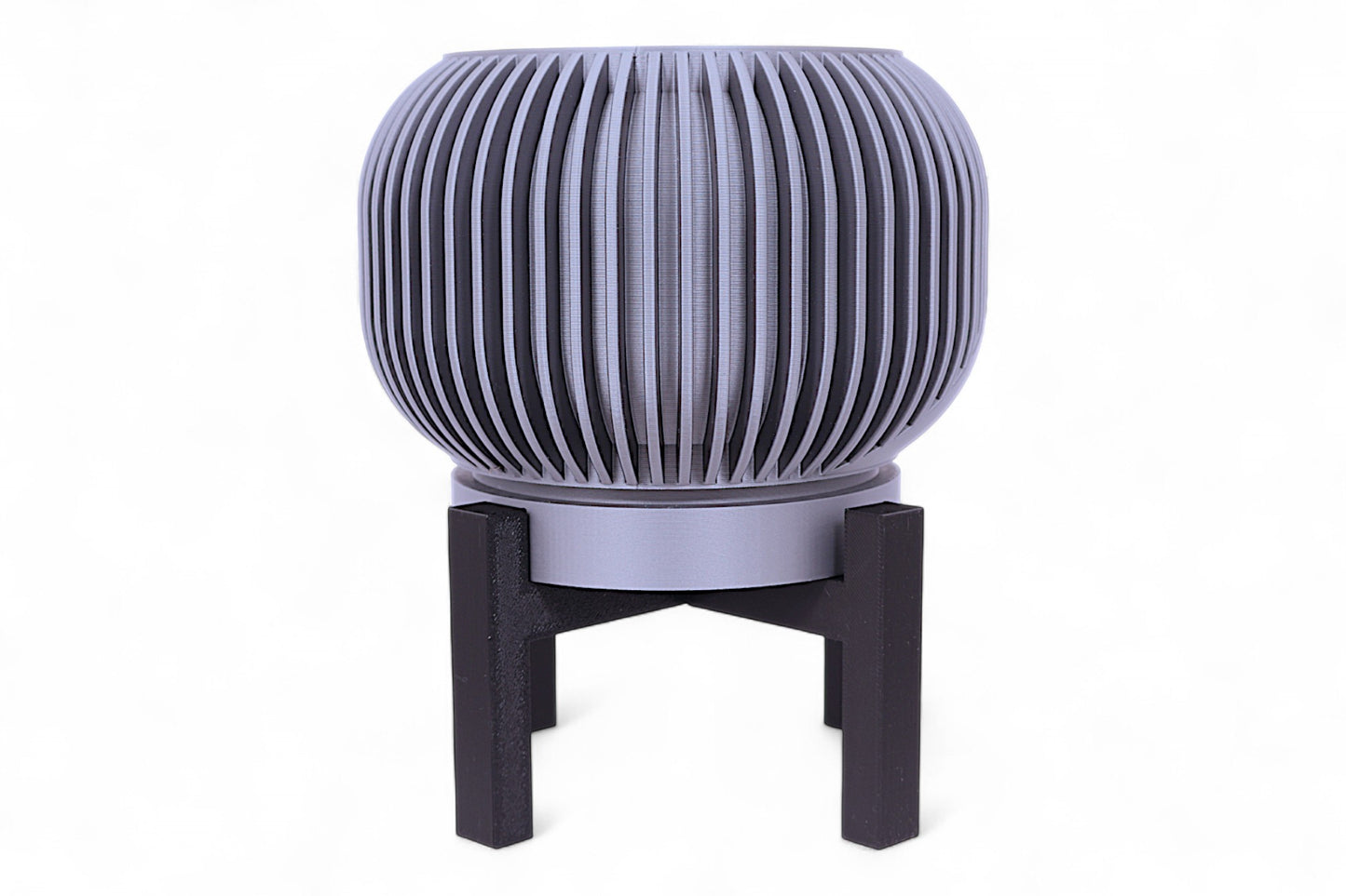 Silver planter with diagonal slatted upper half and smooth lower section on black stand