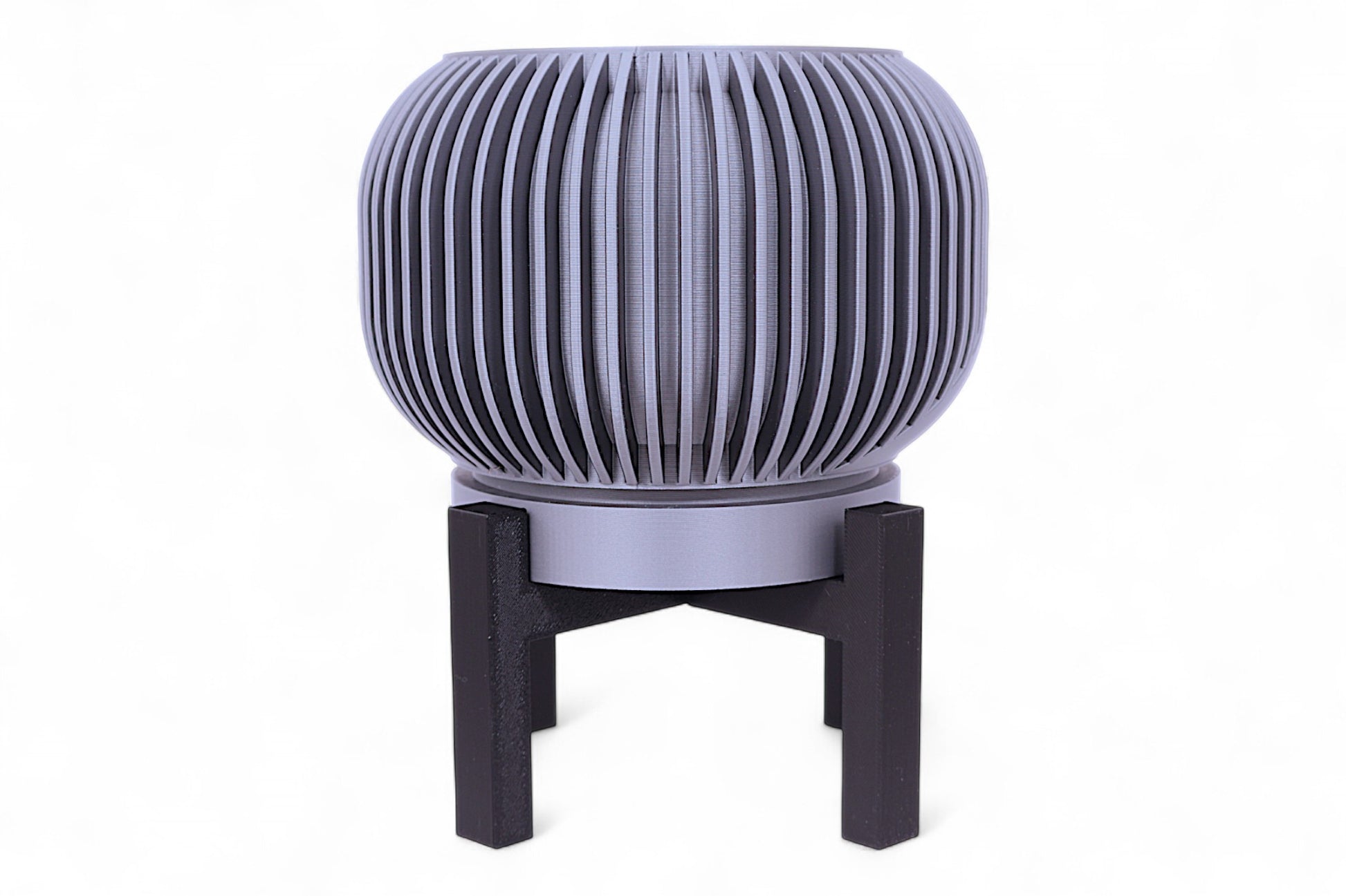 Silver planter with diagonal slatted upper half and smooth lower section on black stand