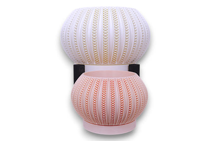 Stacked white and blush pink planters with triangular cutouts separated by black support